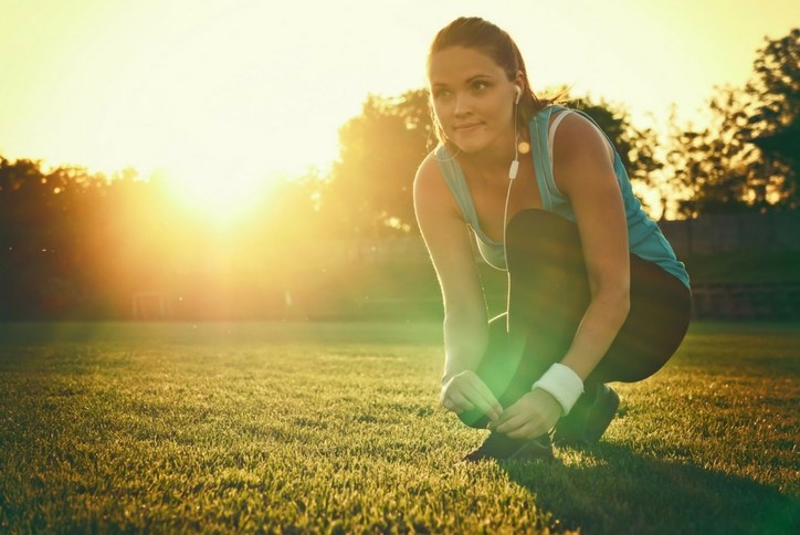 Woman_jogger_tying_shoe_earbuds.jpg