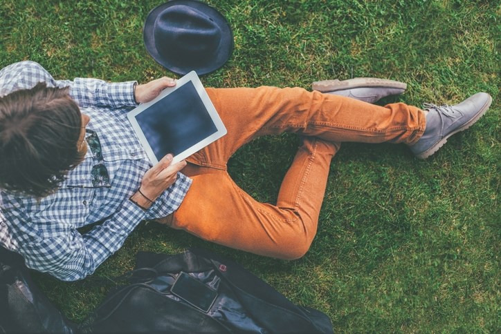 man_sitting_in_grass_with_tablet.jpg