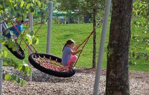 Kids playing on swing at park in Nexton