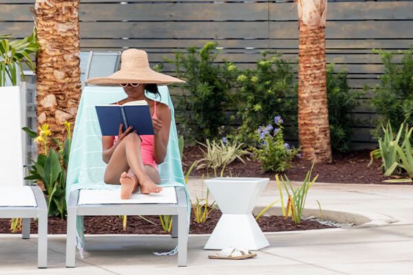 Woman reading in lounge chair at Midtown Club, Nexton